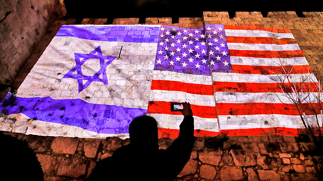 US and Israel flags on the Old City walls  (Photo: AFP)