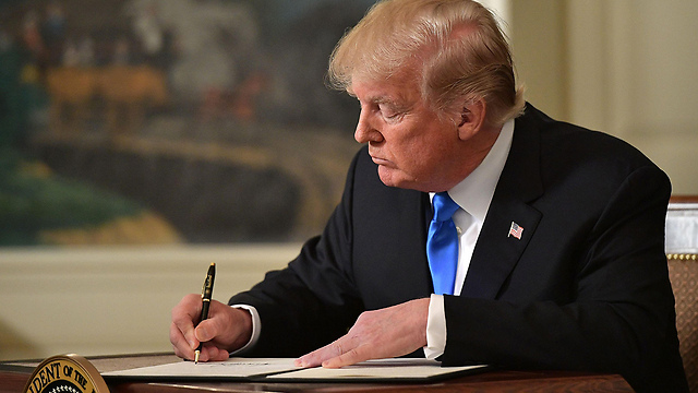 President Trump signs a memorandum after delivering his statement on Jerusalem. The decision was also the result of internal American considerations  (Photo: AFP)