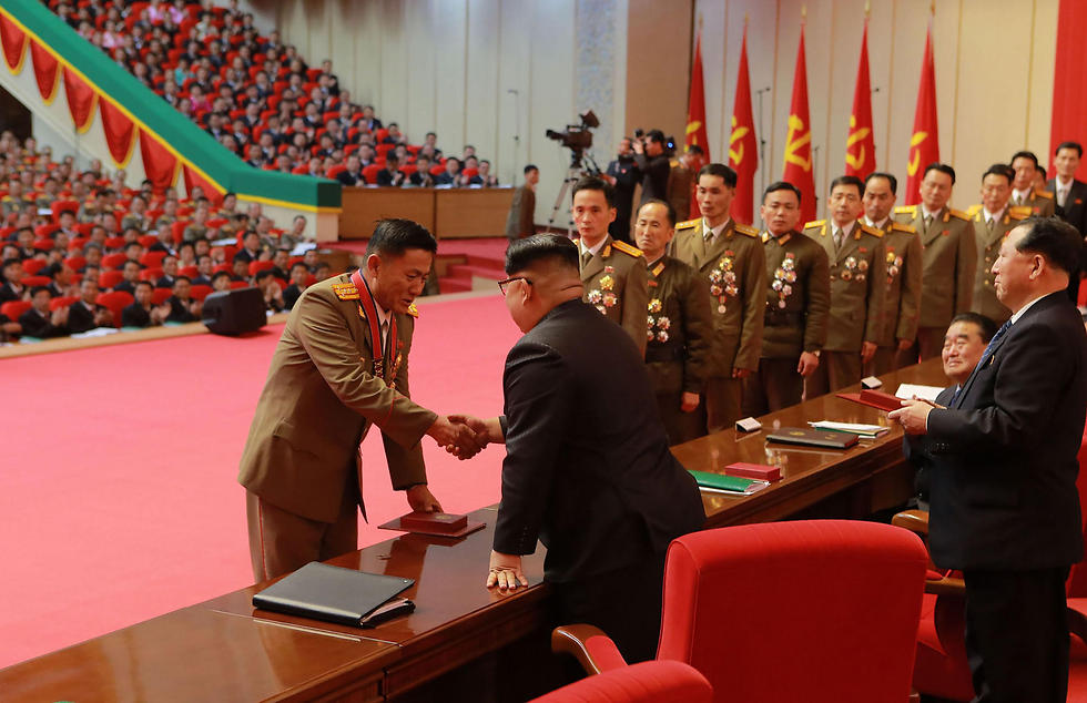 קים מעניק את העיטורים לעובדים המצטיינים (צילום: AFP) (צילום: AFP)