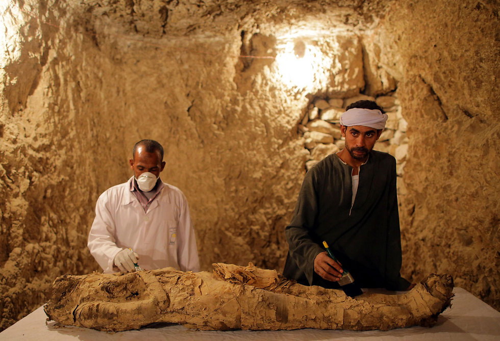 ארכיאולוגים משחזרים מומיה שנמצאה בקבר שהתגלה לאחרונה בלוקסור, מצרים (צילום: EPA) (צילום: EPA)