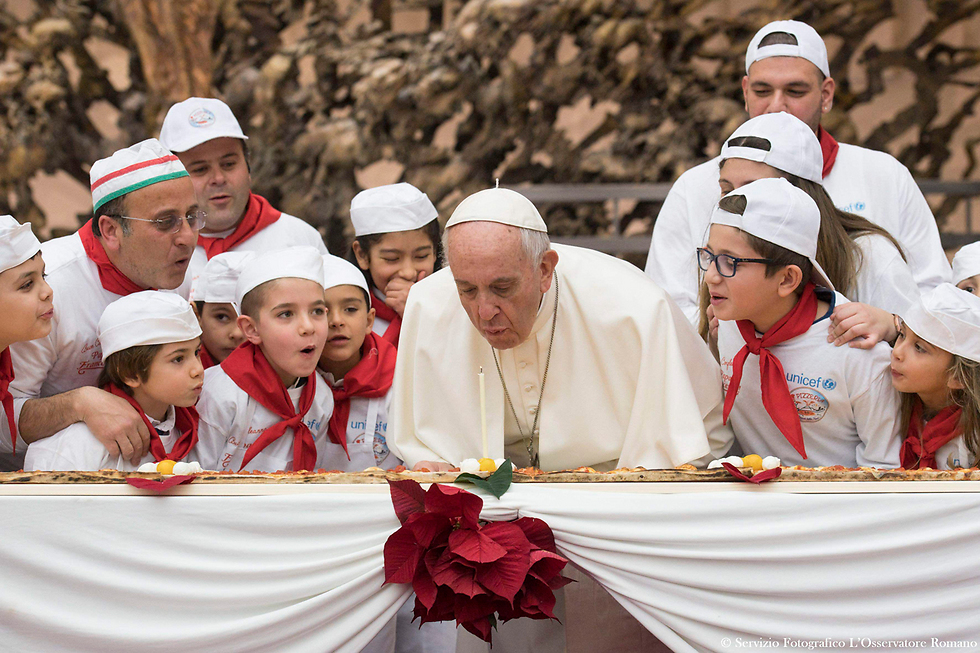 האפיפיור מכבה נר על פיצה ביום הולדתו ה-81 בוותיקן (צילום: AFP, OSSERVATORE ROMANO) (צילום: AFP, OSSERVATORE ROMANO)
