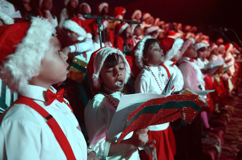 מקהלת ילדים לבושים כסנטה קלאוס בקראצ'י, פקיסטן (צילום: AFP) (צילום: AFP)