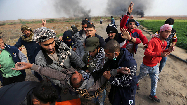 "לא יכול להיות שפספסתי ממרחק כזה". פינוי פצוע פלסטיני (צילום: רויטרס) (צילום: רויטרס)