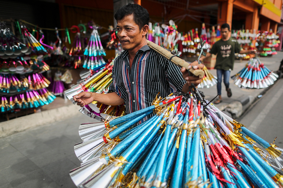 רוכל נושא קרני נייר למכירה לקראת חגיגות השנה החדשה בג'קרטה, אינדונזיה (צילום: EPA) (צילום: EPA)