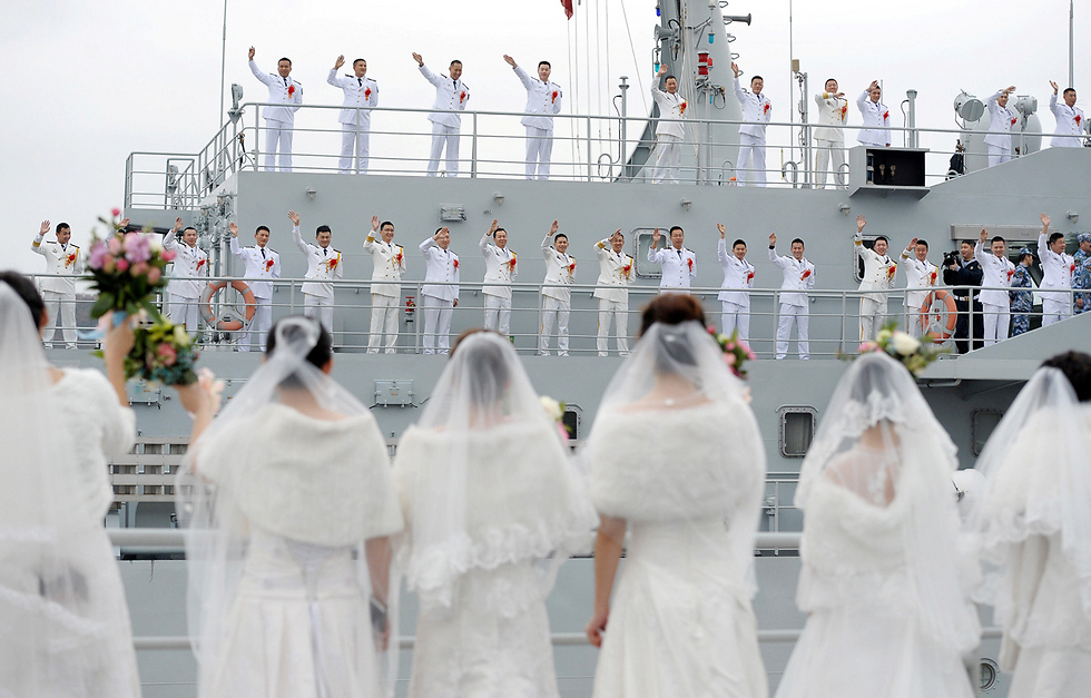 מלחי חיל הים הסיני מנופפים לכלותיהם בחתונה המונית בבסיס צבאי בז'ואושאן (צילום: רויטרס) (צילום: רויטרס)