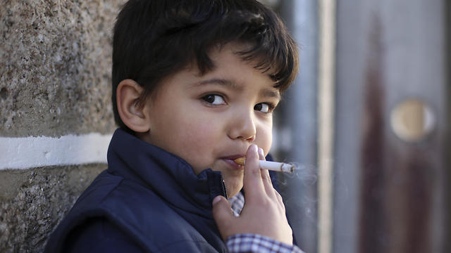 ההורים מרשים. ילד מעשן סיגריה בעיירה ואלי די סלגיירו (צילום: AP) (צילום: AP)
