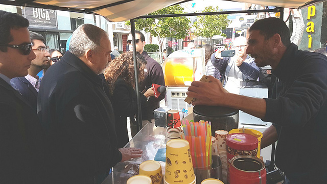 Minister Lieberman making a purchase in Ashdod, Shabbat (Photo: Avi Rokach)