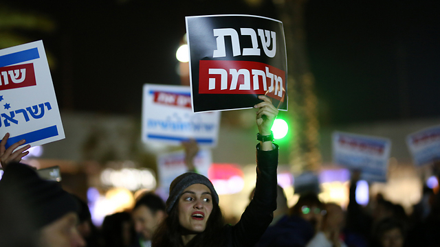 Protestor holds sign reading 'Shabbat war'