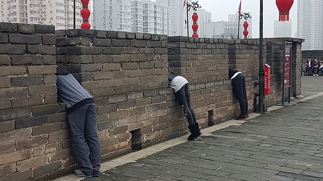 אזרחים מביטים מטה מחומות שיאן (צילום: רון פלד) (צילום: רון פלד)