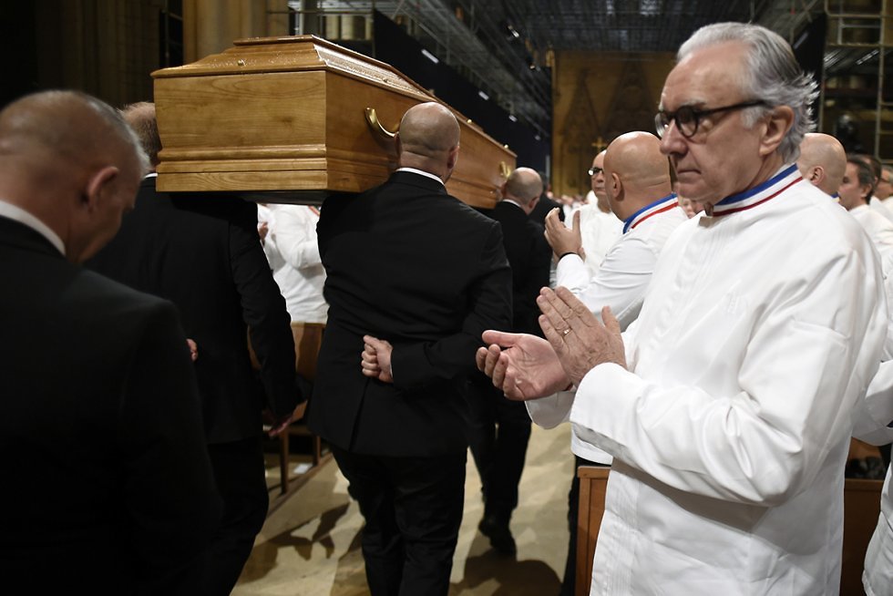 השף אלן דוקאס מוחא כפיים לארונו של פול בוקוז שחולף על פניו בקתדרלת סאן ז'אן (  ) (  )