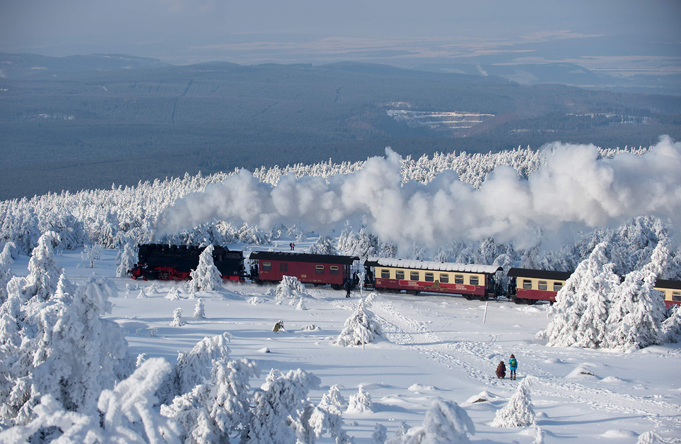 רכבת נוסעת דרך הנוף המושלג של הרי הברוקן בגרמניה (צילום: AFP) (צילום: AFP)