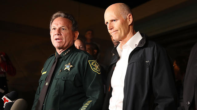 "יום נורא". השריף יזראל (משמאל) ומושל פלורידה סקוט (צילום: AFP) (צילום: AFP)