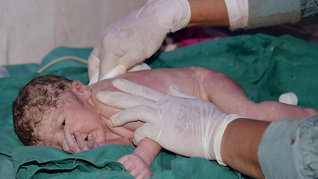 מחסור במיילדות מיומנות. שניות אחרי לידה בפקיסטן (צילום: AFP) (צילום: AFP)