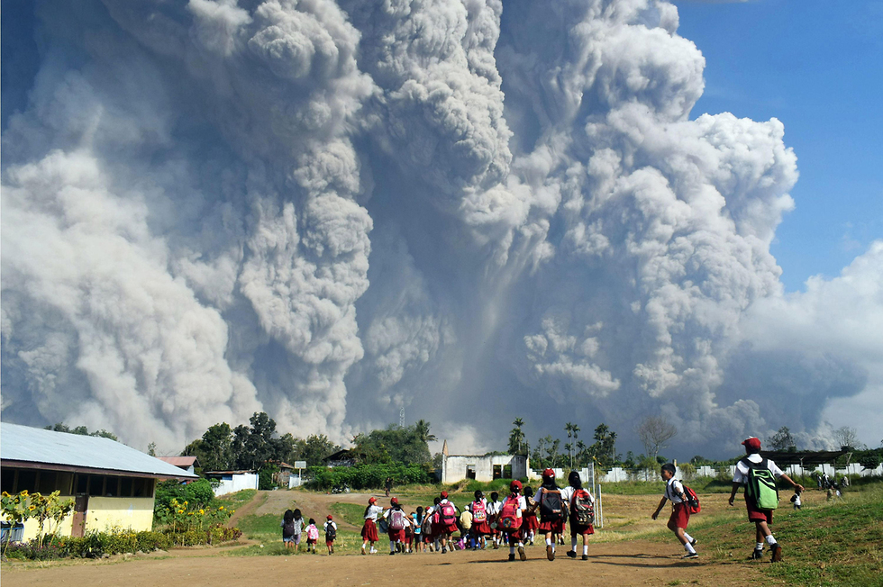 הר הגעש סינבונג פולט אפר בסומטרה, אינדונזיה. תלמידי בית ספר יסודי סמוך משקיפים (צילום: AFP) (צילום: AFP)