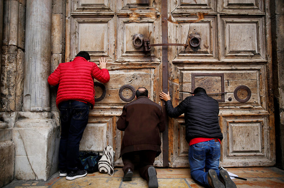 Praying outside the church's closed doors (Photo: Reuters)