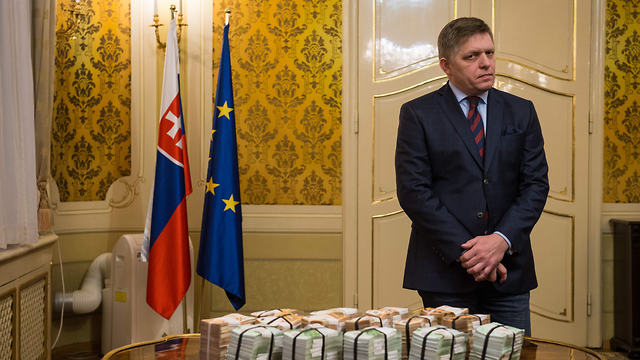 ראש הממשלה הסלובקי הציע פרס של מיליון דולר למי שימסור מידע על הרצח. רוברט פיקו לצד ערימות של שטרות כסף (צילום: AFP) (צילום: AFP)