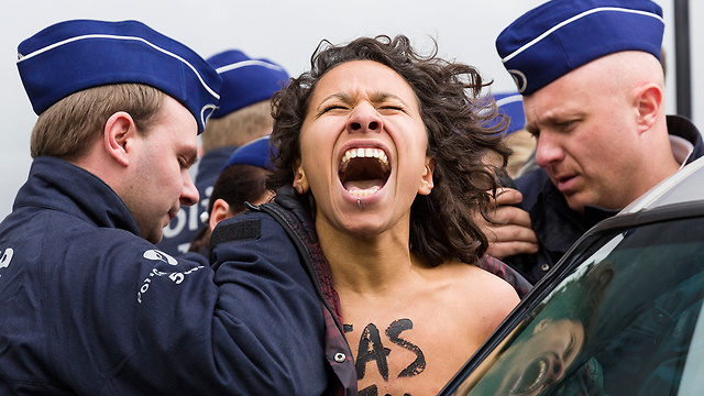 שוטרים עוצרים פעילת Femen בצרפת (צילום: AP) (צילום: AP)