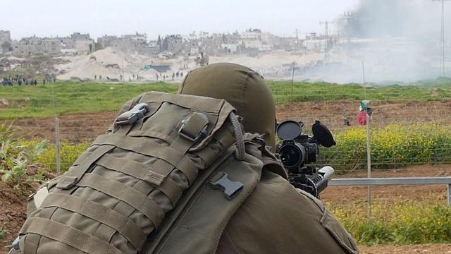 IDF sniper watches as Palestinian protestors riot on Gaza border (Photo: Yoav Zitun)