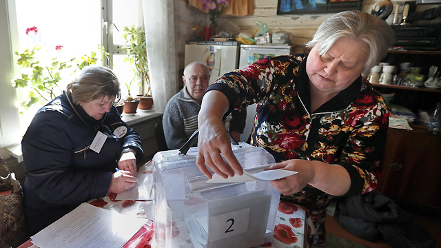 אזרחים מצביעים בקלפי בכפר דדוקינו בבחירות לנשיאות רוסיה (צילום: EPA)