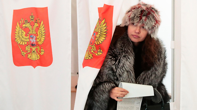 אישה מצביעה בקלפי במוסקבה בבחירות לנשיאות רוסיה (צילום: AP)