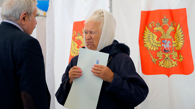 מצביעים בבחירות לנשיאות רוסיה בקלפי במוסקבה (צילום: EPA)
