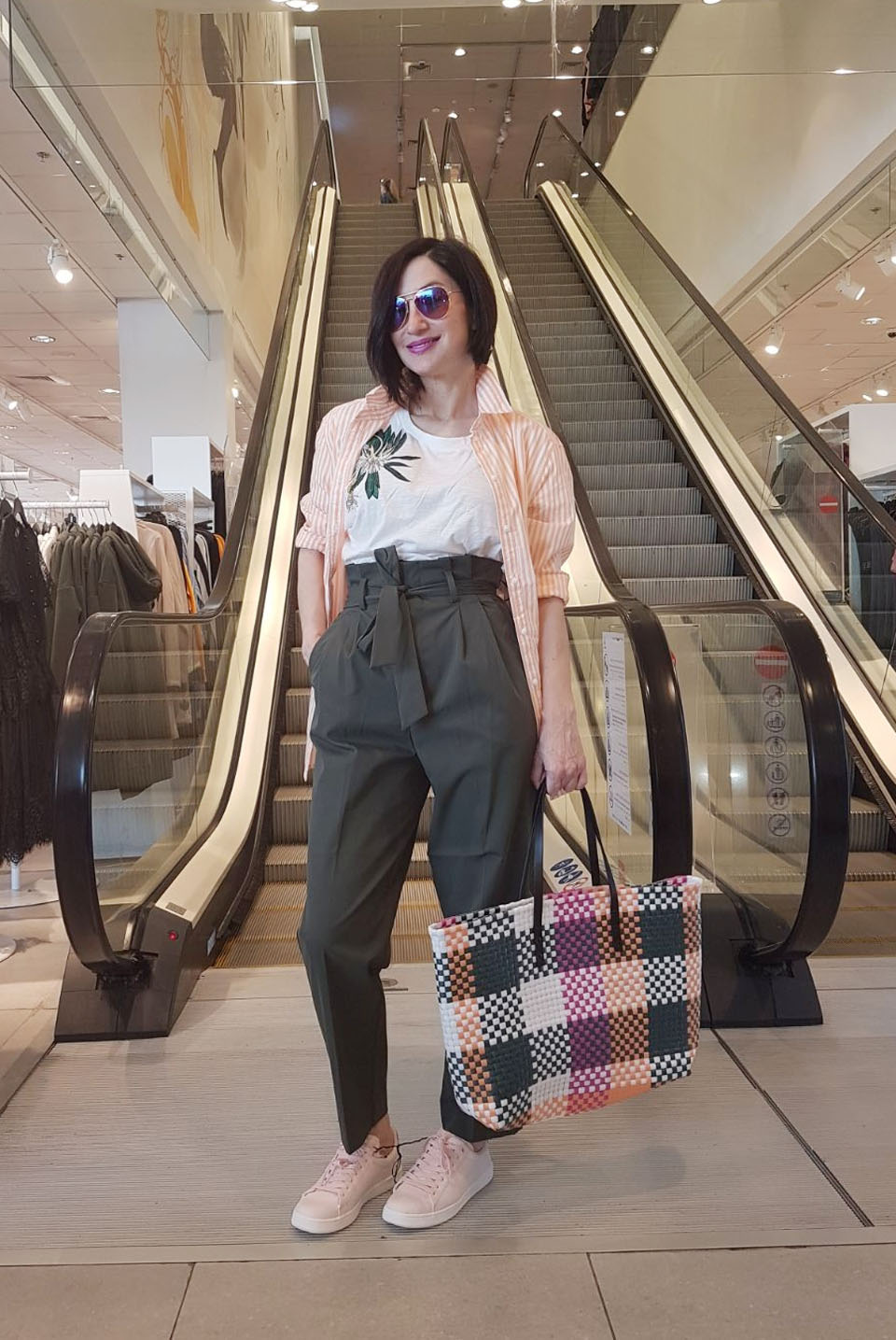  Образ в стиле кэжуал-спорт: брюки paperbag, свободная футболка, полосатая рубашка, лаконичные сникерсы и трендовая плетеная сумка-шопер от H&M