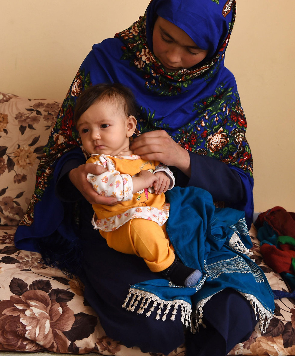 סטודנטית אפגנית שנבחנה עם התינוק שלה (צילום: AFP)