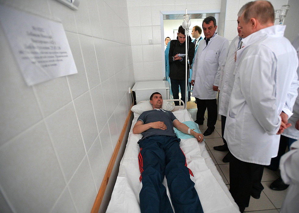 ולדימיר פוטין מבקר פצועים מהשריפה בעיר קמרובו (צילום: AFP)