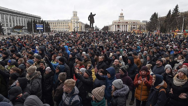 אנשים עומדים לזכר ההרוגים ב שריפה בקניון קמרובו רוסיה (צילום: AFP)