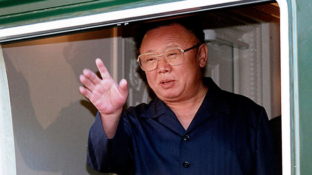 שליט צפון קוריאה קים ג'ונג איל מנופף בידיו מתוך רכבת 20 באוגוסט 2002 (צילום: AP)