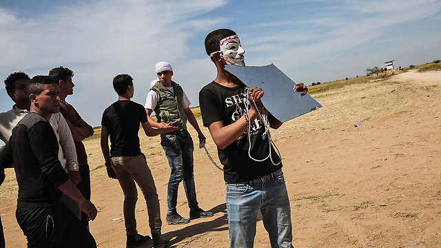 Palestinians holding up mirrors to blind IDF snipers (Photo: AFP)