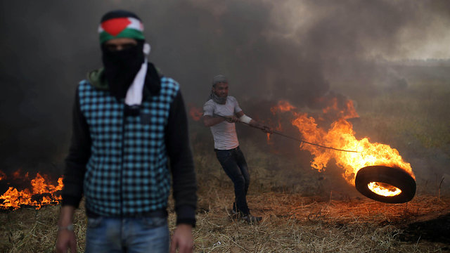 פלסטינים שורפים צמיגים בגבול רצועת עזה (צילום: רויטרס)