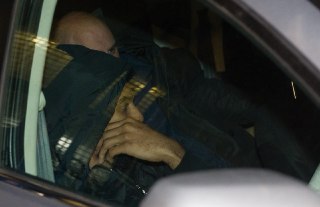 גלן רייס מסתתר ביציאה מתחנת המשטרה (צילום: עוז מועלם)
