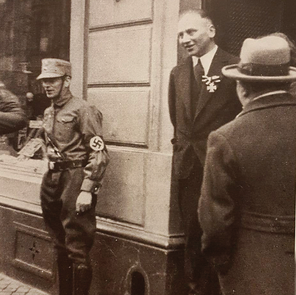 הצילום ההיסטורי שהחל את המסע: שטרן עונד את עיטור הגבורה בפתח חנותו בגרמניה, מתייצב עם חיוך מול הנאצים שקוראים להחרים אותו