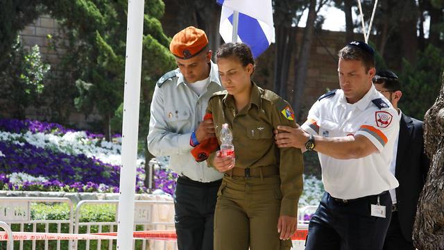 Генерал Авив Кохави помогает девушке-солдату, которая потеряла сознание во время церемонии Дня памяти павших солдат. Фото: Шауль Голан