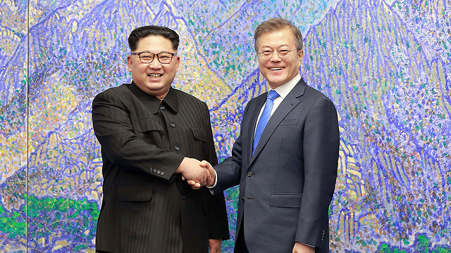 שני המנהיגים לוחצים ידיים (צילום: AFP PHOTO/KCNA VIA KNS)