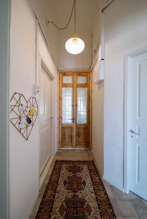 דלת הכניסה עוצבה מעץ מפירוקים  (צילום: אילן נחום)