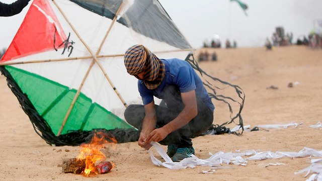 Alborotador palestino prepara cometa incendiaria en la frontera de Gaza (Foto: AFP)