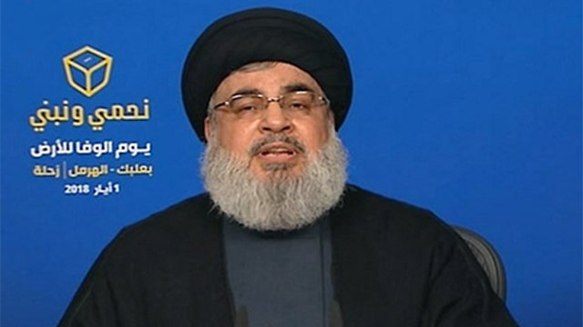 Nasrallah with the ‘Defending and Building’ slogan 