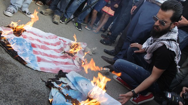 Protesters in Jordan burn flags (Photo: EPA)
