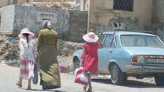 A Palestinian woman and her daughters return from Ramadan shopping  (Photo: Yoav Zitun)
