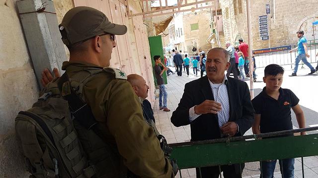 Hebron Brigade Commander Col. Itzik Cohen with a local resident  (Photo: Yoav Zitun)