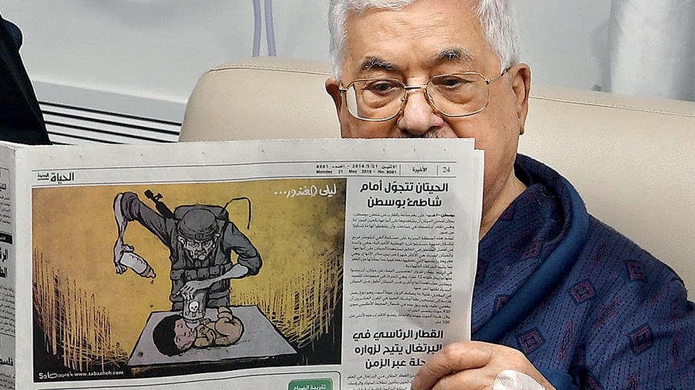 PA President Abbas reading Monday's Al-Hayat al-Jadida (Photo: Reuters)