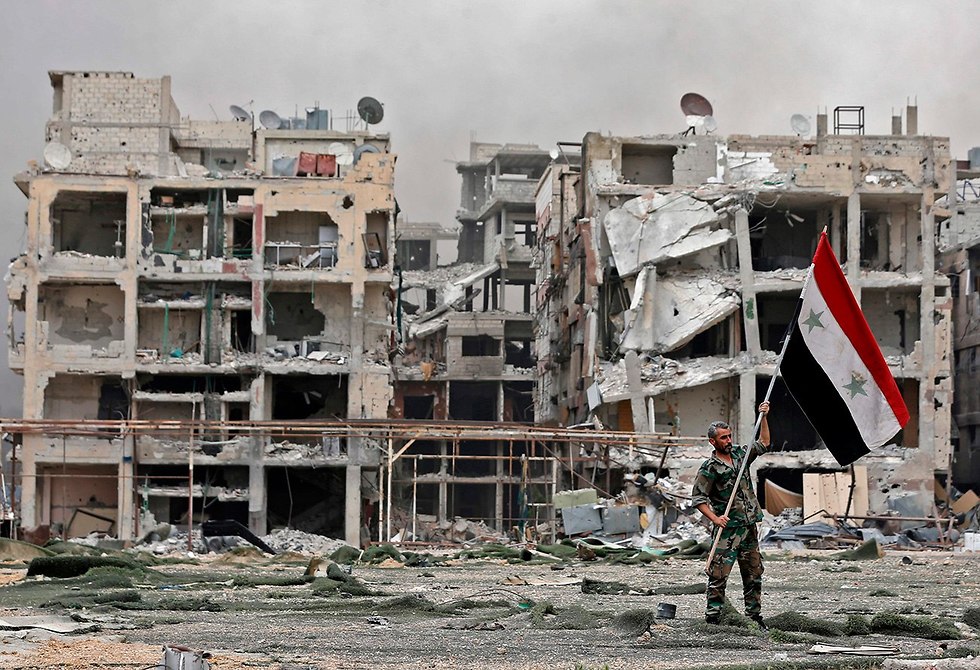 חייף מניף דגל סוריה ב מחנה פליטים ירמוכ (צילום: AFP)
