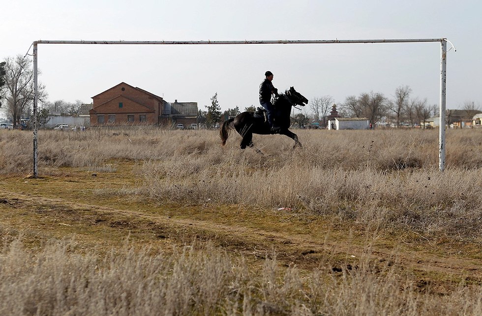 גבר רוכב על סוס ליד שער ב כפר בולשאייה גדז'אלגה אזור סטברופול רוסיה (צילום: רויטרס)