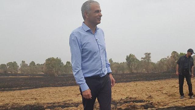 Treasury Minister Kahlon during a tour of a burned field in the Be'eri kibbutz (Photo: Haim Horenstein)