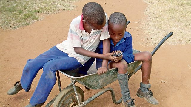 ילדים באפריקה משחקים בסמארטפון (תצלום: שאטרסטוק)