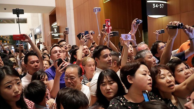 Tourists and Singapore residents taking photos of Kim outside the hotel  (Photo: EPA)