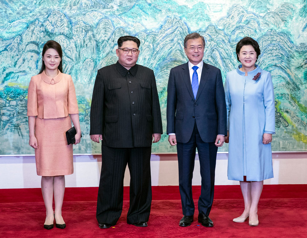 חליפת חצאית בהירה ושמרנית למפגש ההיסטורי עם נשיא קוריאה הדרומית ורעייתו. משמאל: רי סול-ג'ו (צילום: AP)