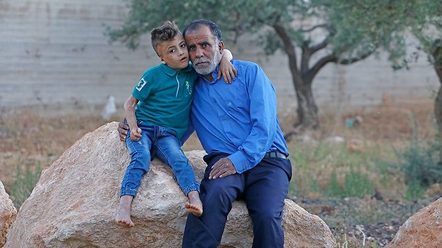 Hussein Dawabsheh with his grandson Ahmed, the only one to survive the attack (Photo: Shaul Golan)